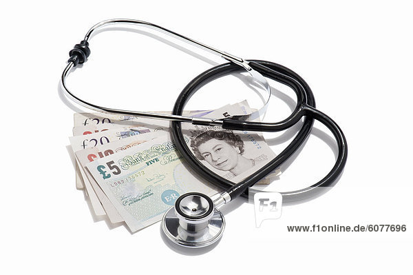A doctors stethoscope and British pound notes