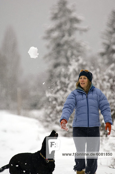 A woman playing with her dog Bella on property in wintry Whitefish  MT.
