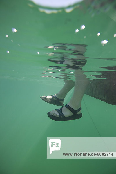 Underwater view of feet dangling in water.