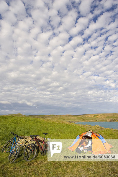 A young woman resting in a tent after mountain biking along the Reykjavik Peninsula Iceland.