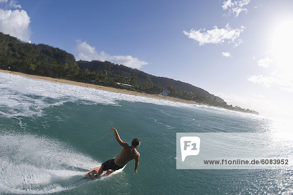 A young man surfing past the camera at Pupukea  on the north shore of Oahu  Hawaii.