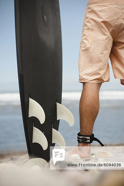 stehend  Mann  Felsen  Strand  Surfboard