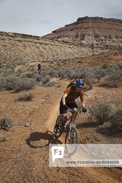 Man mountain biking down a desert trail near Hurricane  Utah.
