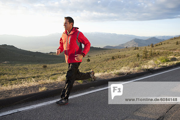 An athletic man running on a mountain road in South Lake Tahoe  California.