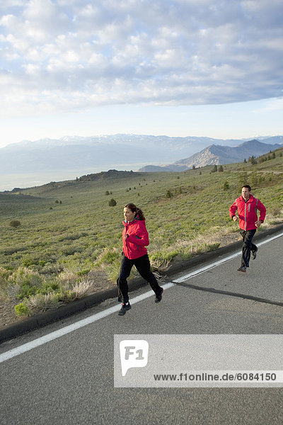 An athletic couple running on a mountain road in South Lake Tahoe  California.
