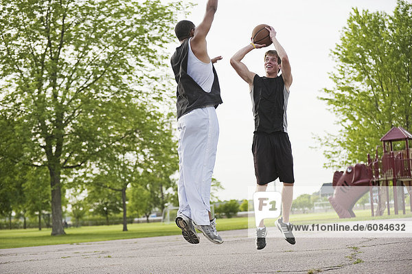 Two young men play one on one Basketball at Barstow Park in Vermillion  South Dakota.