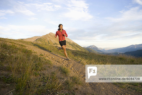 A woman trail running in Gunnison National Forest  Colorado.