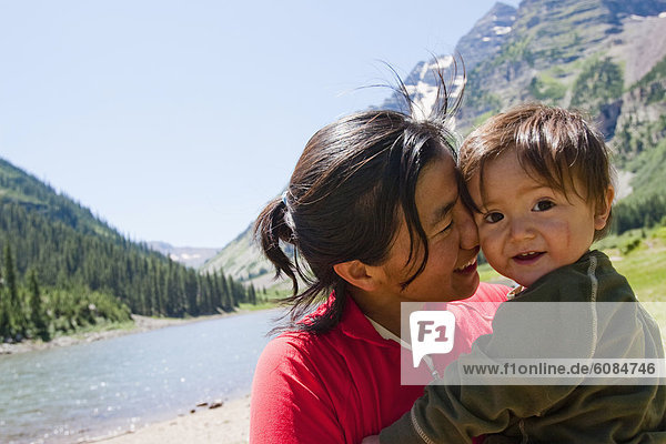 A mother and her child at Crater Lake in the Maroon Bells in Snowmass Wilderness on a multi-day backpacking trip.