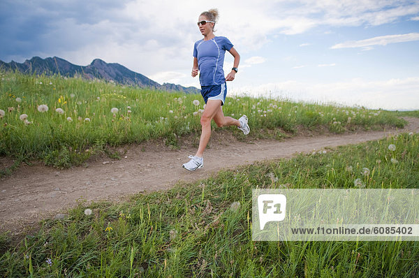 A female marathon runner trains on a trail in Boulder  Colorado.