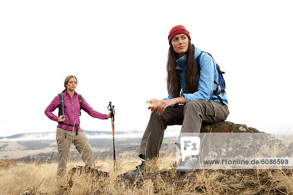 Two females take a break to check the compass while hiking in the Columbia Gorge  Oregon in autumn.