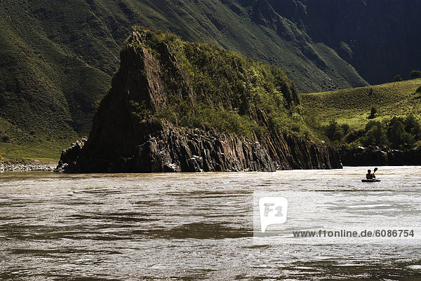 A kayak heads downstream while whitewater rafting in Western China.
