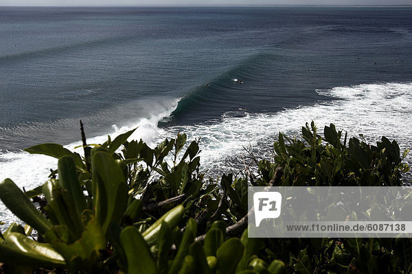A surfer rides a wave at Balangan  Bali  Indonesia.
