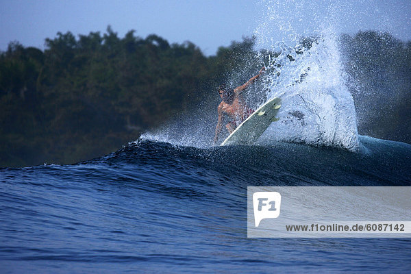 A surfer lands an aerial move at G-Land  Java  Indonesia.