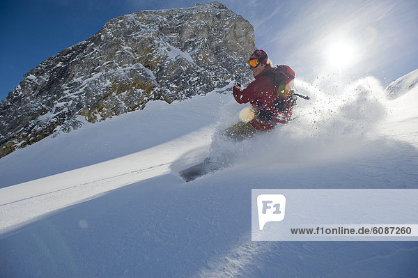 Gegenlicht  Berg  Snowboardfahrer  lächeln  fahren  Gesichtspuder  unbewohnte  entlegene Gegend  Selkirk Mountains  Kanada