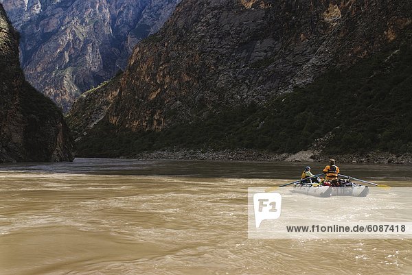 A rubber raft rows downstream during a whitewater rafting trip to Western China.