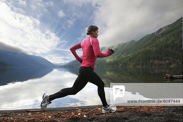 A female jogging along the Lake Crescent shore.