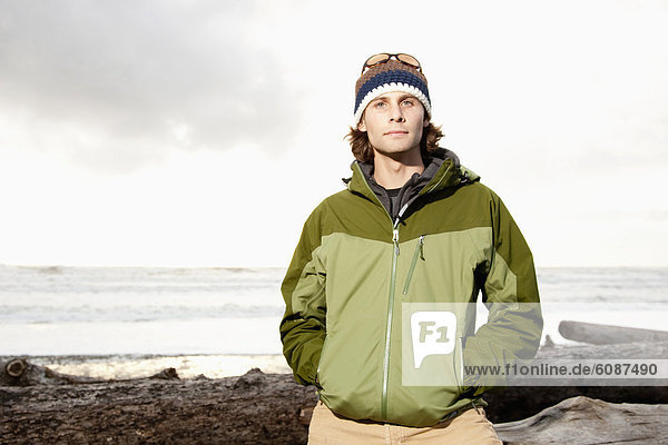 Portrait of young  outdoorsy man in jacket and hat while hiking at La Push Beach  Washington.