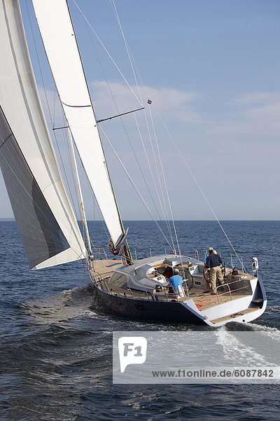 A crew races a modern ocean-going sailing yacht.