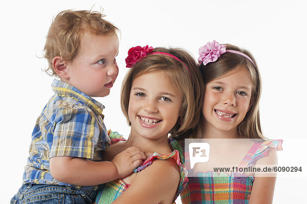 Junge und Mädchen lächeln vor weißem Hintergrund  Portrait