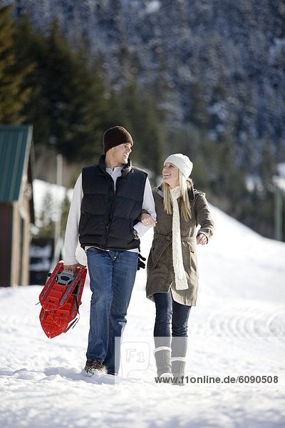 A man and woman enjoy a day of snow shoeing activities in the mountains.
