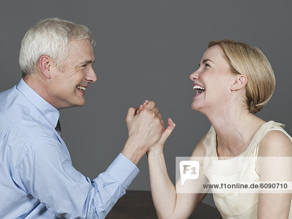 Mature couple arm wrestling  smiling