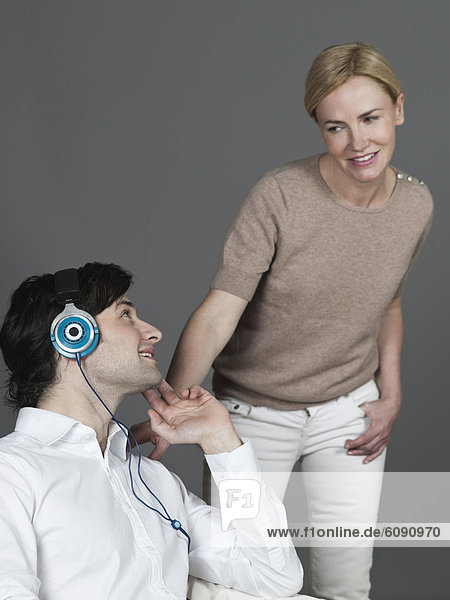 Man with earphones  woman looking at him