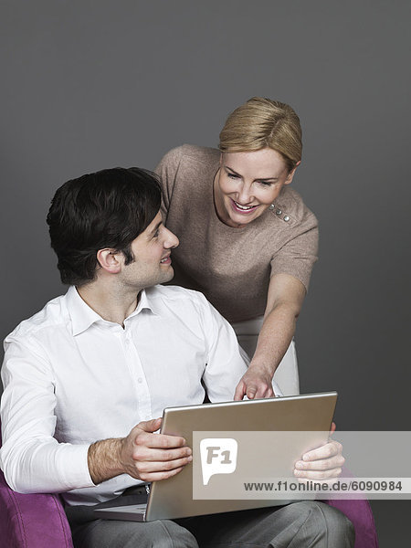 Man and woman with laptop  smiling