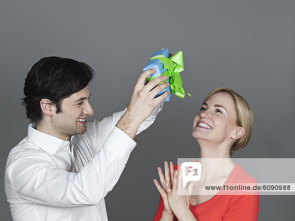 Man giving gift to woman  smiling