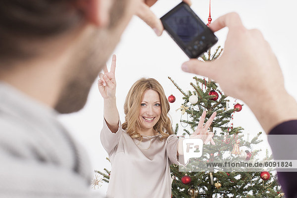 Mid adult man taking photograph of woman  smiling
