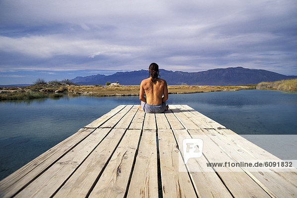 A man sitting at the end of a dock in Cuatro Cicnigas  Mexico.