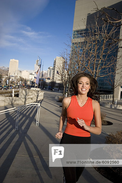 A young woman jogs downtown.
