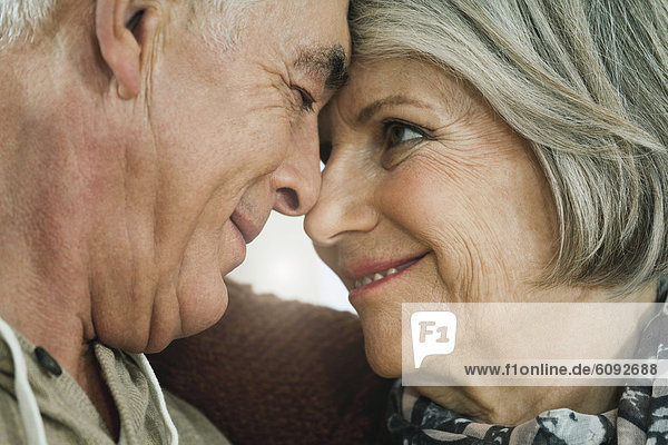 Deutschland  Berlin  Seniorenpaar schaut sich an  lächelnd