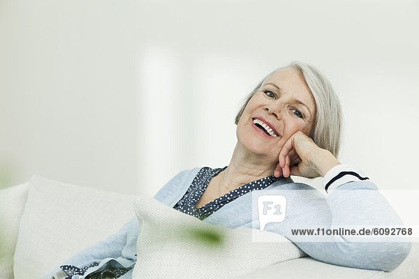 Seniorin auf Couch  lächelnd  Portrait