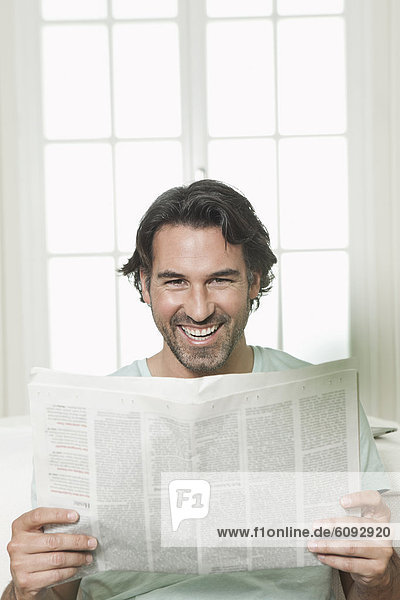 Mature man with newspaper  smiling  portrait