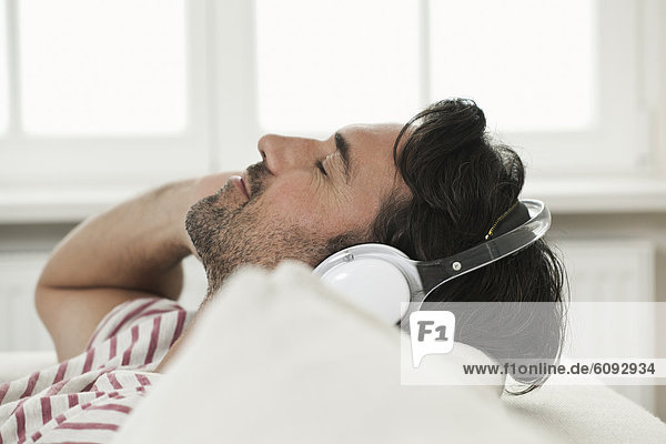 Mature man listening music with head phones