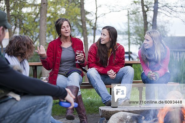 sitzend  sprechen  Fröhlichkeit  Freundschaft  camping  Getränk  Feuer
