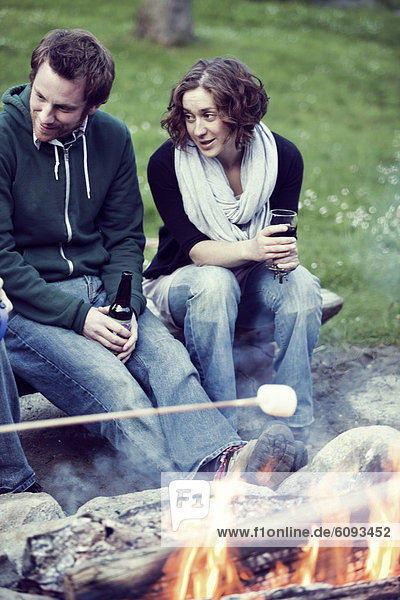 sitzend  sprechen  Fröhlichkeit  Freundschaft  camping  Getränk  Feuer  2  Marshmallow