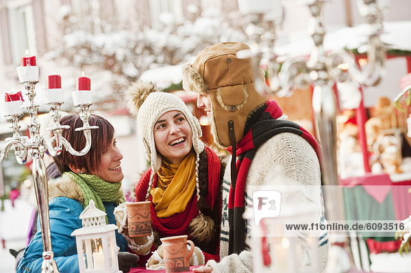 Österreich  Salzburg  Mann und Frau auf dem Weihnachtsmarkt  lächelnd