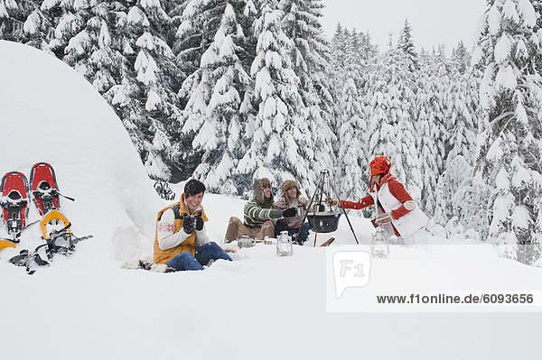 Österreich  Salzburg  Männer und Frauen am Kamin im Winter