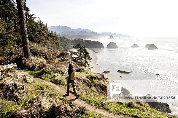 A woman hiking a secluded path along the coastline.