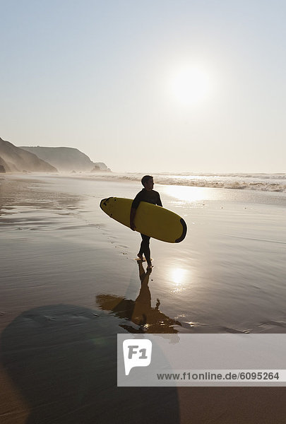 Portugal  Surfer walking on beach