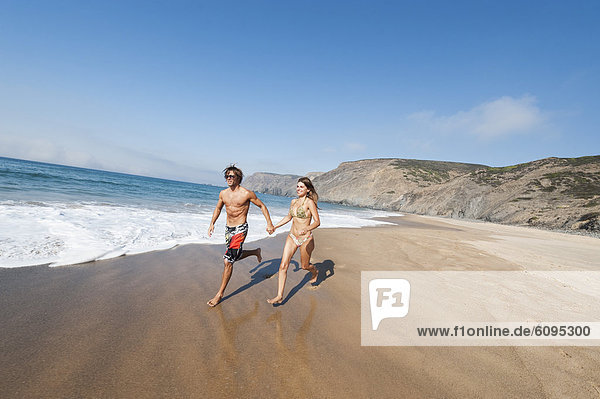 Portugal  Couple running on beach