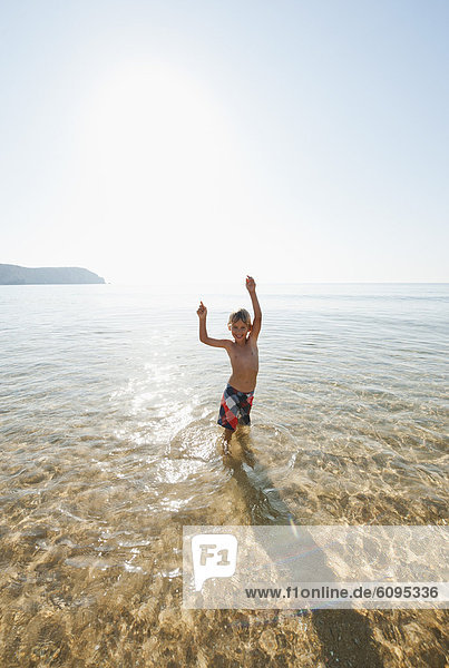 Portugal  Junge steht im Wasser am Strand