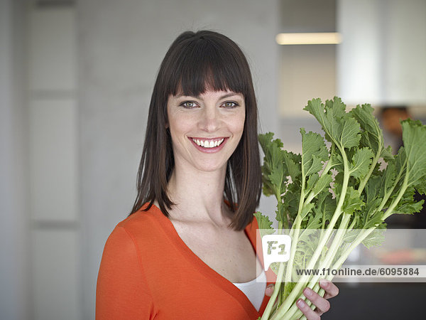 Mittlere erwachsene Frau mit Gemüse  lächelnd  Portrait
