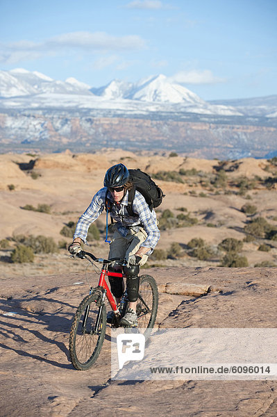 A young man rides his mountain bike on the Slickrock Trail  Moab  UT.