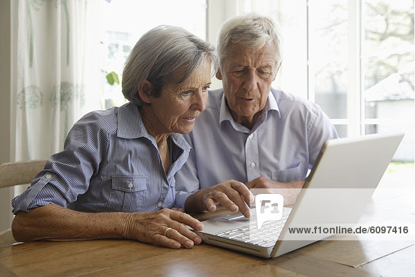 Germany  Bavaria  Senior couple using laptop at home