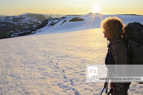 Backpacker looking back at sunrise while crossing Drangaj+kull ice cap  Hornstrandir Peninsula  Iceland
