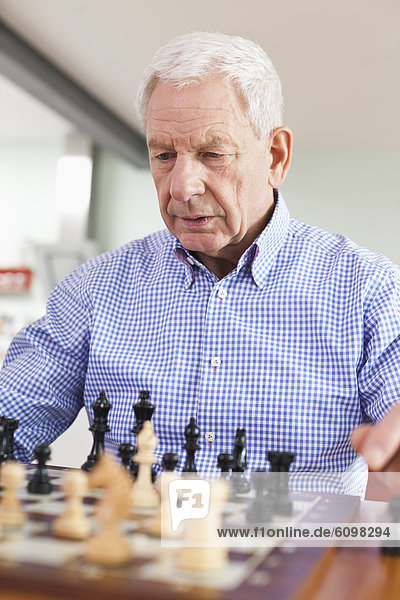 Senior man playing chess game