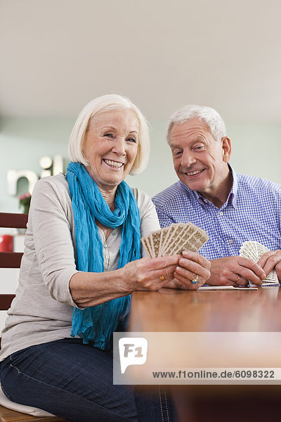 Senior man and woman playing card game  smiling
