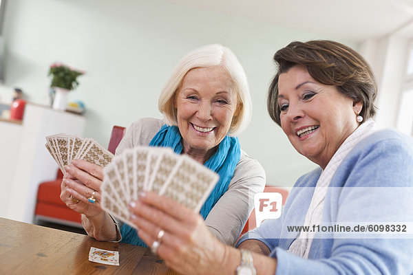 Senior women playing card game  smiling